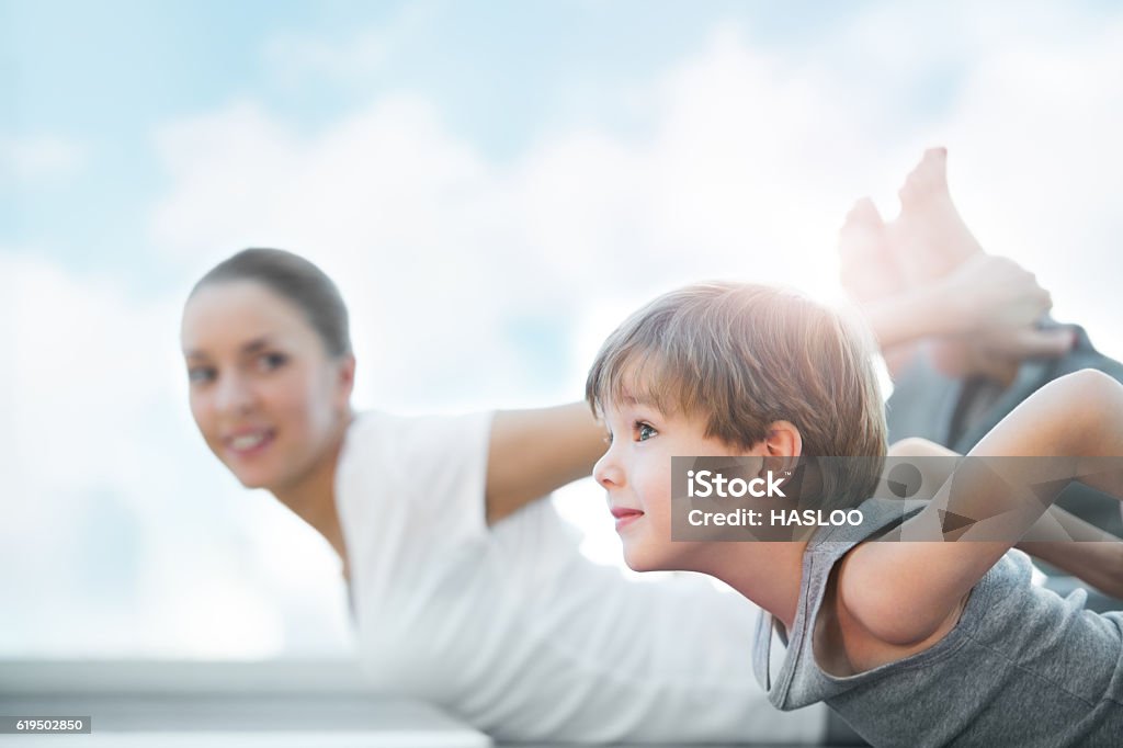 Healthy family Healthy family - mother and son doing exercises against blue sky Yoga Stock Photo