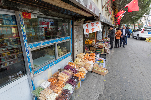 Urumqi, Xinjiang, China- October 13, 2016: Urumqi downtown street view. Retail stores on the road sides, incidental people on the background.