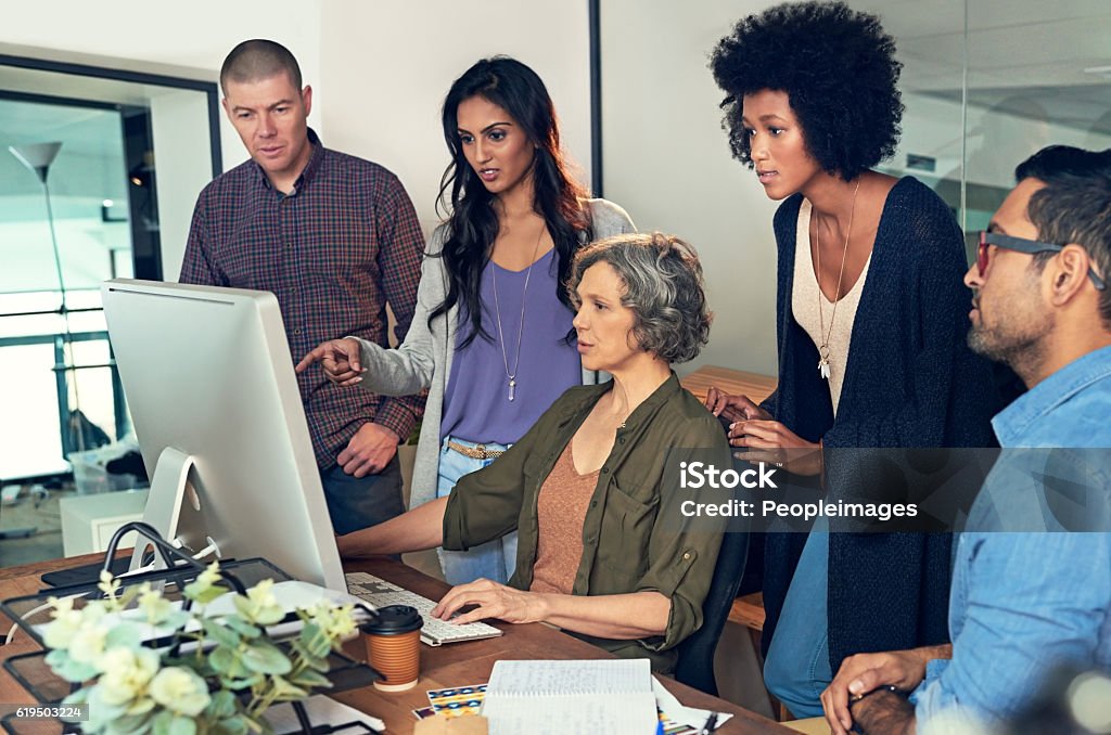 It's important to share critique and criticism as a team Cropped shot of a group of businesspeople discussing something on a computer in an office 30-39 Years Stock Photo