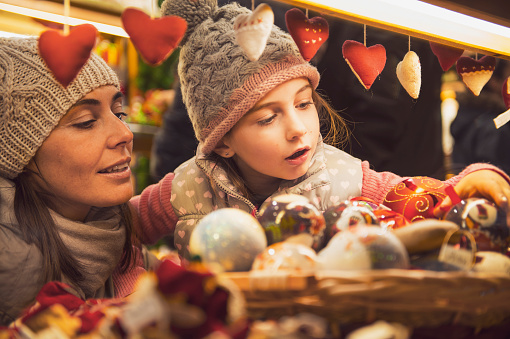 mother and daughter selecting decoration on a Christmas market - retro look vinatge