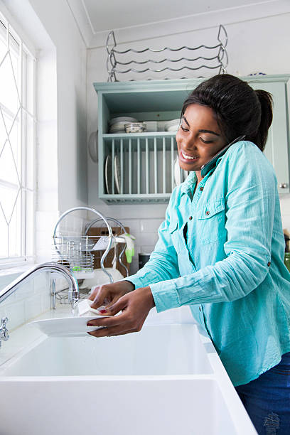 istock African female doing the dishes. 619506426