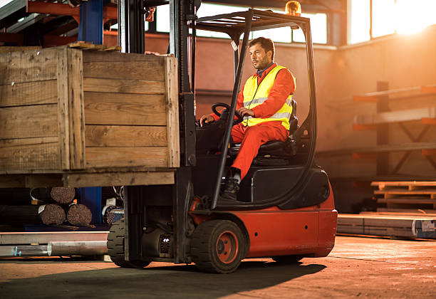 istock Mid adult worker driving forklift with palette in distribution warehouse. 619506698
