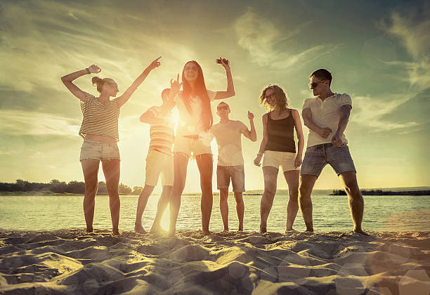 istock Friends funny dance on the beach under sunset sunlight. 619507096