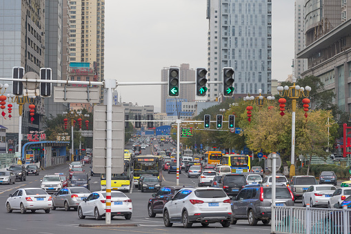 Urumqi, Xinjiang, China - October 14, 2016: Urumqi downtown street view. Office buildings on the background, Cars and incidental people at front.