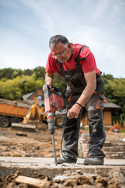 istock Mature construction worker drilling the concrete outdoors. 619508480