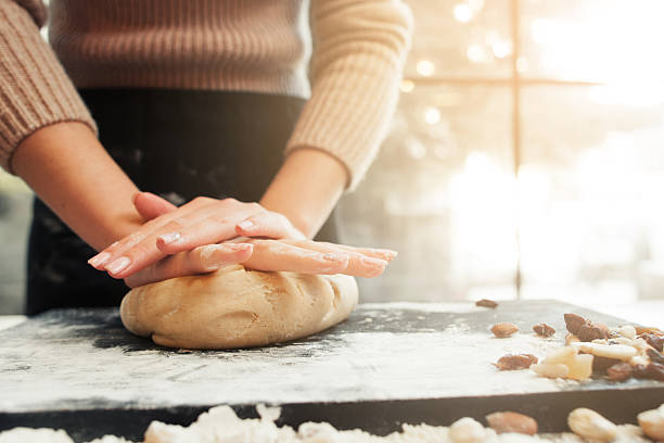 manos femeninas amasando masa, fondo de puesta de sol - home baking fotografías e imágenes de stock