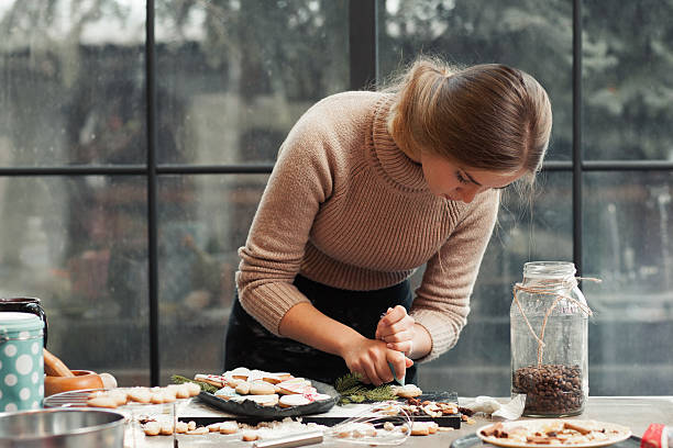 istock Young woman decorating pastry at kitchen 619509054