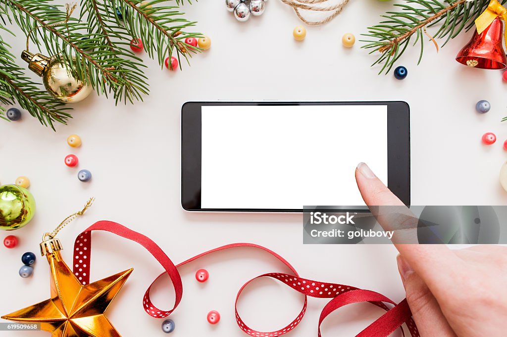 Woman using smartphone, Christmas discounts Woman using smartphone with blank screen, festive trumpery frame. Christmas gift search, online shopping, seasonal discounts and sale concept Christmas Stock Photo