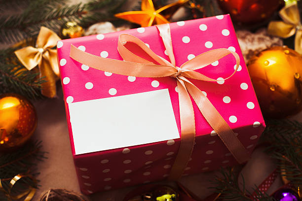 istock Pink gift box with blank card under Christmas tree 619509724