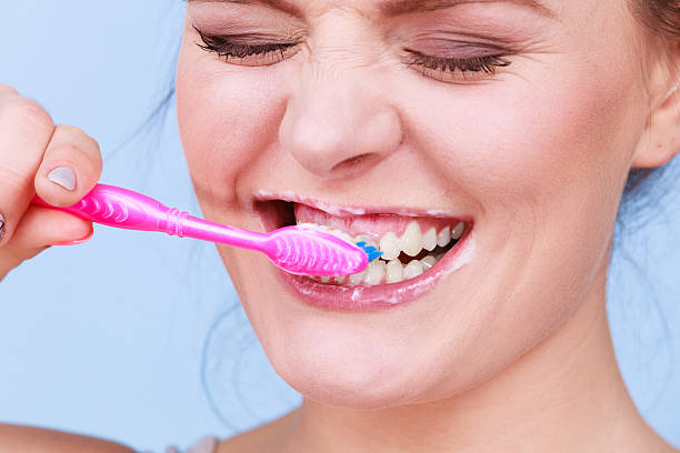 istock Woman brushing cleaning teeth 619510268