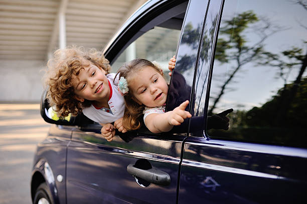 istock children look out from a car window 619512004