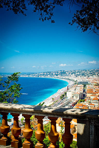Nice France beach Nice, France - July 31, 2015: The beach on the Mediterranean sea in Nice, France.  This is on a hot July summers day with many holiday makers and tourists on the beach sunbathing with an ornamental ballustrade and trees in the foreground. islamic state stock pictures, royalty-free photos & images