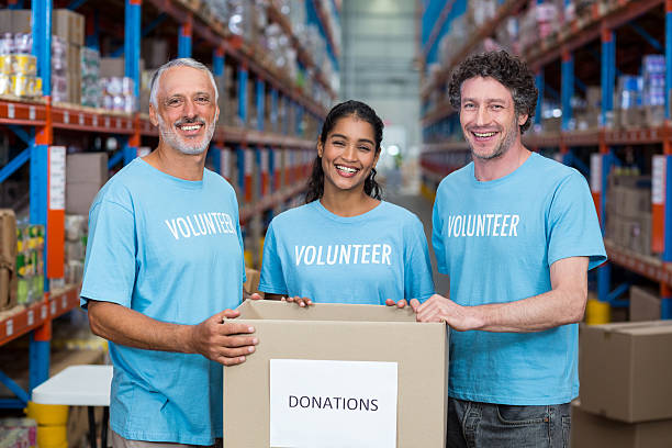 istock Portrait of three volunteers holding a donations box 619514254