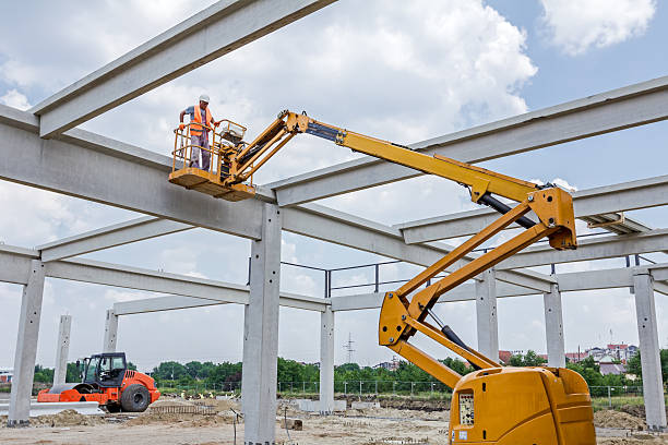 Rigger is in the cherry picker on construction site Zrenjanin, Vojvodina, Serbia - June 4, 2015: Building activities during construction of the large complex shopping mall "AVIV PARK" in Zrenjanin city.  hydraulic platform photos stock pictures, royalty-free photos & images