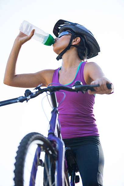 istock Female cyclist drinking water 619516100