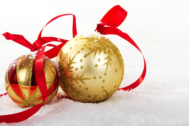 Gold Christmas decorations in white snow for background stock photo