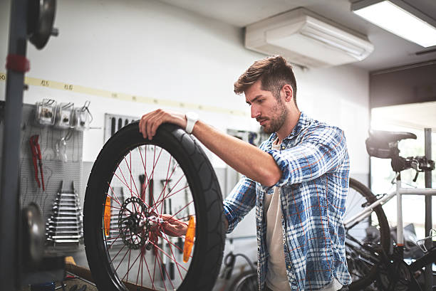 istock Mechanic repairing bicycle wheel 619520284