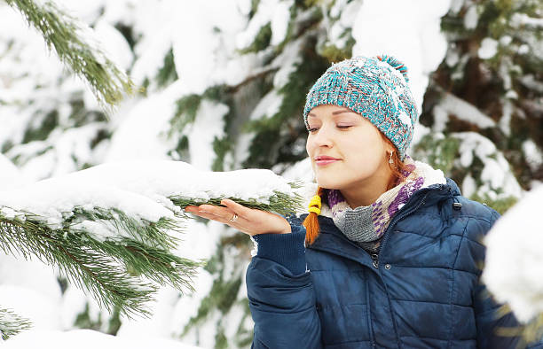 istock Happy beautiful girl stands next to snowy pine tree 619520706