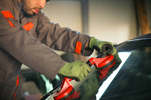 istock Mechanic changing glass on car. 619521438