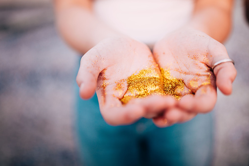 Close-up of Hands holding golden glitter