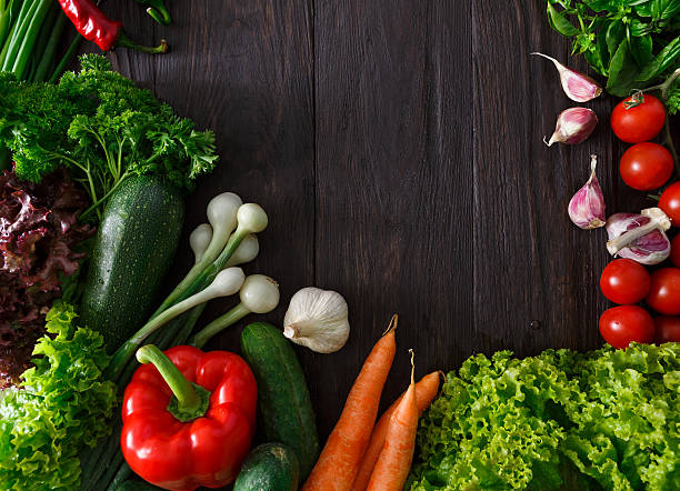 istock Border of fresh vegetables on wooden background with copy space 619521934
