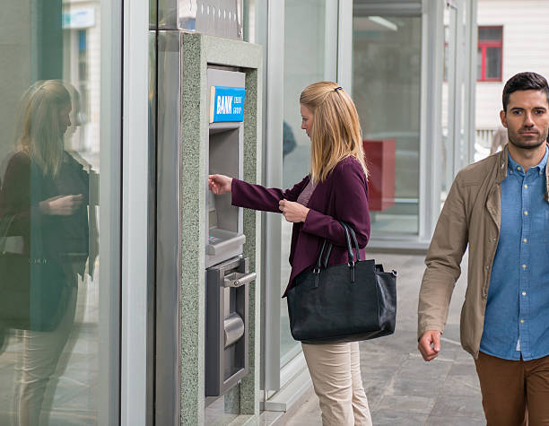istock Young Woman Taking Money From ATM 619522580