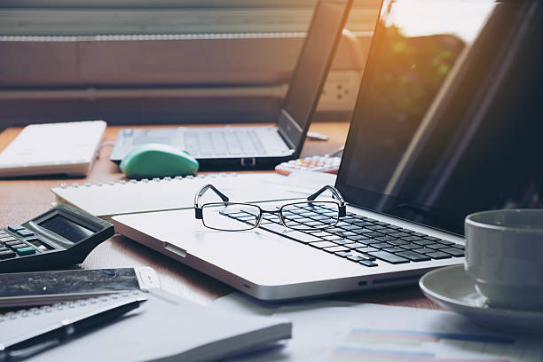 istock Eyeglasses on laptop keyboard and diary on wooden table 619527344