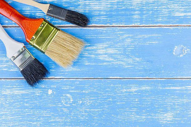 istock Paint brushes on blue wooden table background copy space 619529984