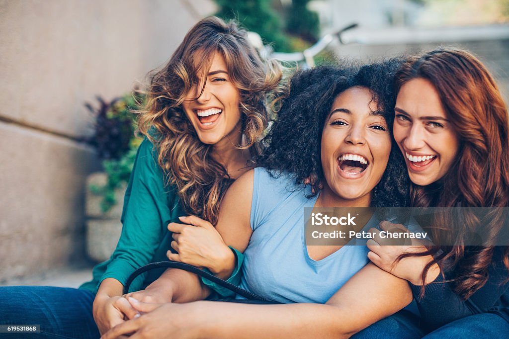 Happy girlfriends Three young women laughing outdoors Friendship Stock Photo