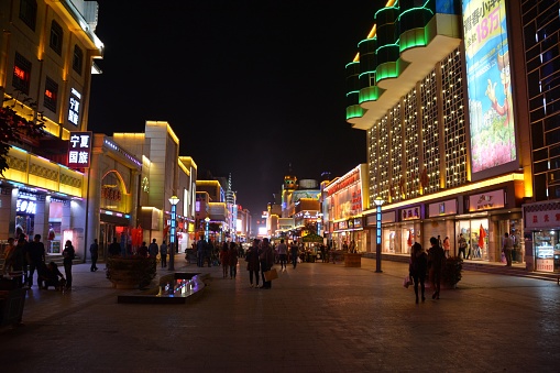 Yinchuan, China - October 6, 2014: People walking on Xinhua shopping street at night, a main street in Yinchuan - Ningxia Hui Region - North China.