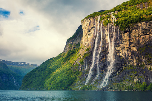 Geiranger fjord. Seven Sisters Waterfall, Norway. Mountain landscape with cloudy sky. Beautiful nature.