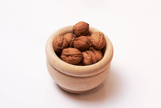 istock Nuts in wooden bowl on white background 619533288