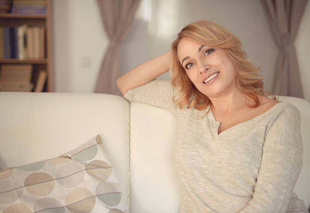 istock beautiful middle-aged woman in home interior 619534398