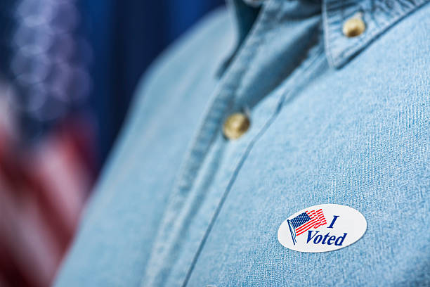 istock Man with I VOTED sticker after casting ballot 619536386