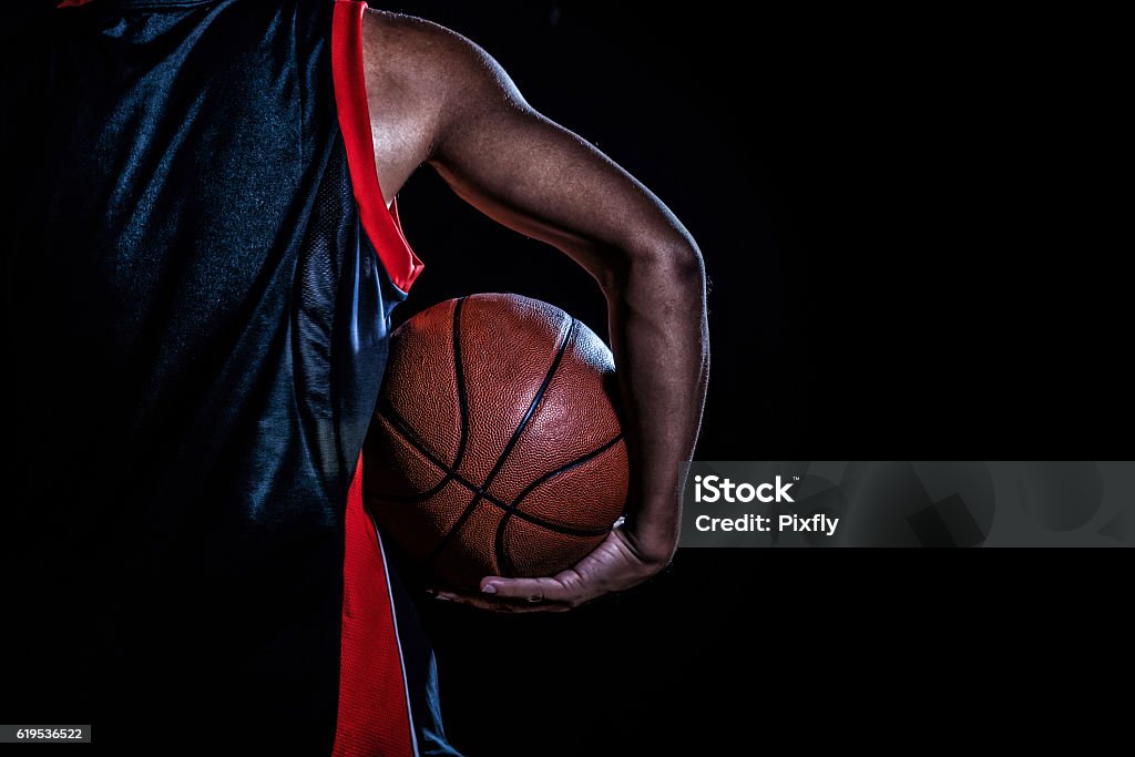 jugador de baloncesto con una pelota sobre fondo oscuro - Foto de stock de Baloncesto libre de derechos