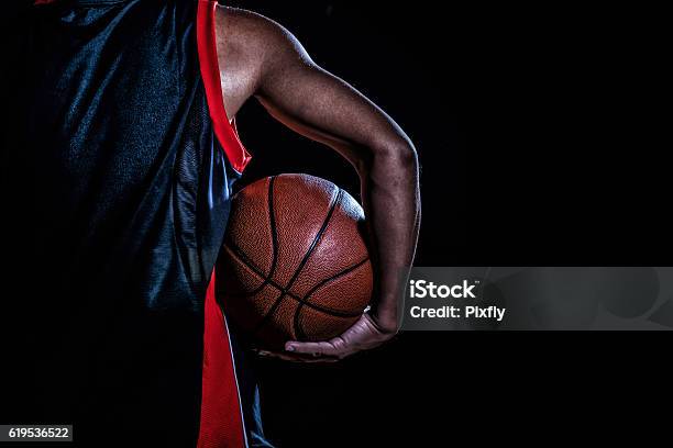 Foto de Jogador De Basquete Com Uma Bola Em Fundo Escuro e mais fotos de stock de Basquete - Basquete, Bola de Basquete, Jogador de Basquete