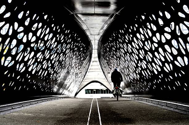 rowerzysta przekraczający most tunelowy - bicycle lane zdjęcia i obrazy z banku zdjęć