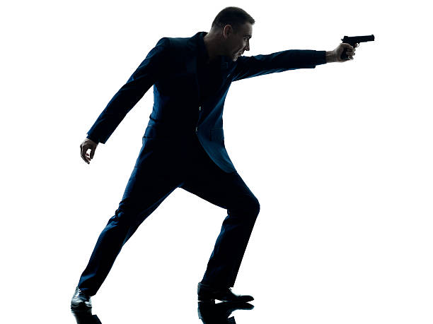 istock man with a handgun silhouette isolated 619538486