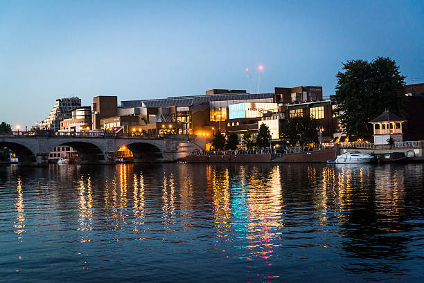 Kingston Bridge,  Surrey, England, UK Kingston upon Thames, Surrey, England, UK - August 29, 2016: Kingston Bridge over the river Thames and Kingston riverside which is lined with restaurants and a popular spot with locals and tourists. The Thames river reflects the city lights at night. surrey england stock pictures, royalty-free photos & images