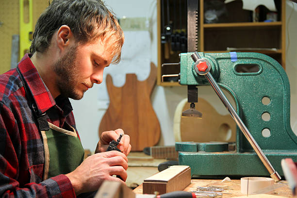 istock Luthier Woodworker Building Guitar in Workshop 619539844