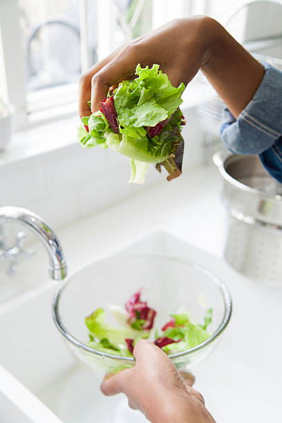 istock African female rinsing lettuce. 619541510