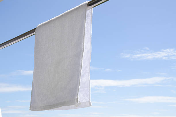 istock Washed White Towel Hanging Against Blue Sky 619541968