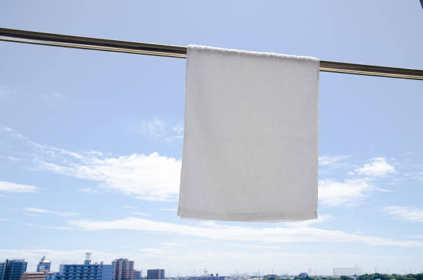 istock Washed White Towel Hanging Against Blue Sky 619542112