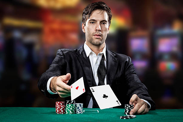Poker player Poker player showing a pair of aces, on a cassino background. texas hold em photos stock pictures, royalty-free photos & images