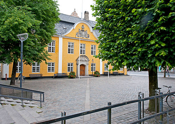 Aalborg,Denmark - June 22, 2016: Imposing and grandly ornate facade of a Danish mansion house set within a cobbled and tree-lined square. Many traders became became so fortunate and successful in business that they became some of the country's leading traders. This is originally the home of a prosperous merchant in Aalborg, Denmark