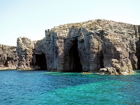 Along the cliffs of the island of San Pietro, cavities and sea caves