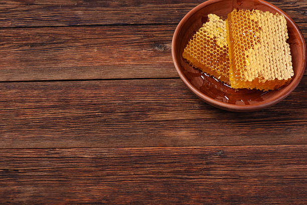 istock honey in comb on a wooden rustic table, copy space 619543062