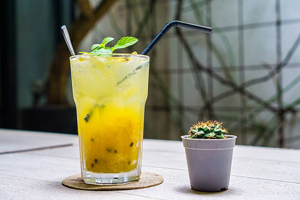 Sparkling Drink : Passion fruit-Mango Soda to quench your thirst on the wooden table with small Cactus decoration 