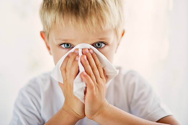 istock Sick little boy cleaning his runny nose. 619543262