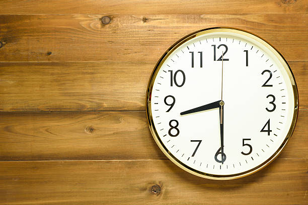 istock wall clock on the wooden wall 619545420